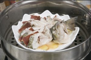將鱸魚成花狀擺好，將火腿切片放入各縫隙中，放入鍋中隔水蒸12分鐘拿出，撒上蔥花即可。