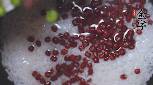 將炒好的食材和大米、紅豆一起放進(jìn)電飯鍋煮。