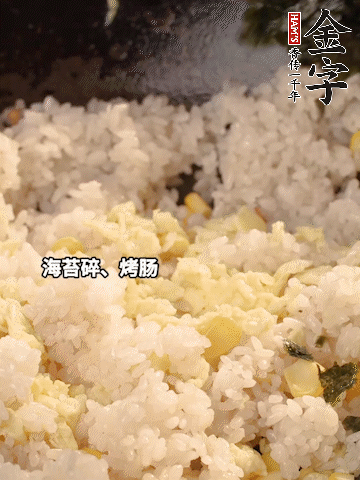 剩米飯下鍋炒散，依次下玉米粒、雞蛋、烤腸、海苔碎翻炒均勻。