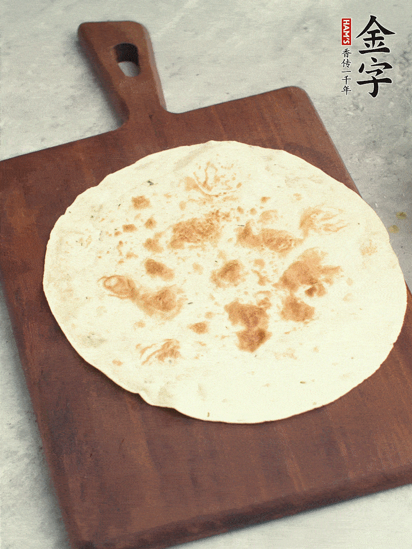 食材依次鋪在卷餅皮上，卷起來。