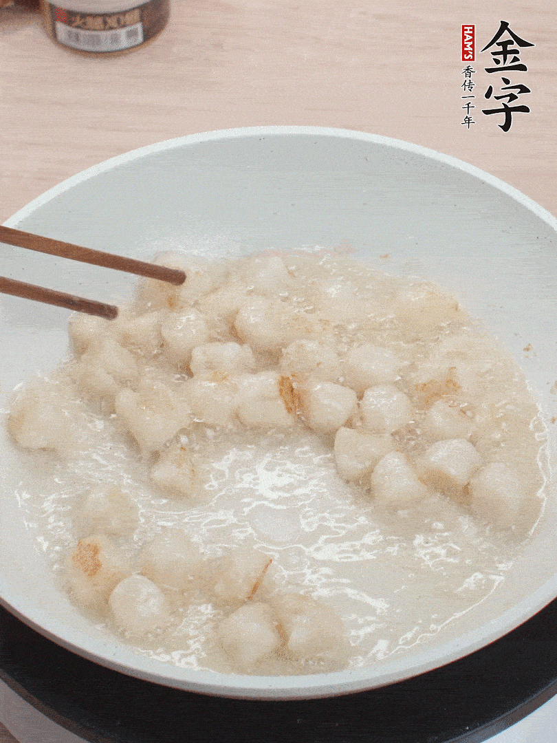 油溫4成熱，鮮貝蘸干淀粉下鍋煎，一面微黃后翻面。