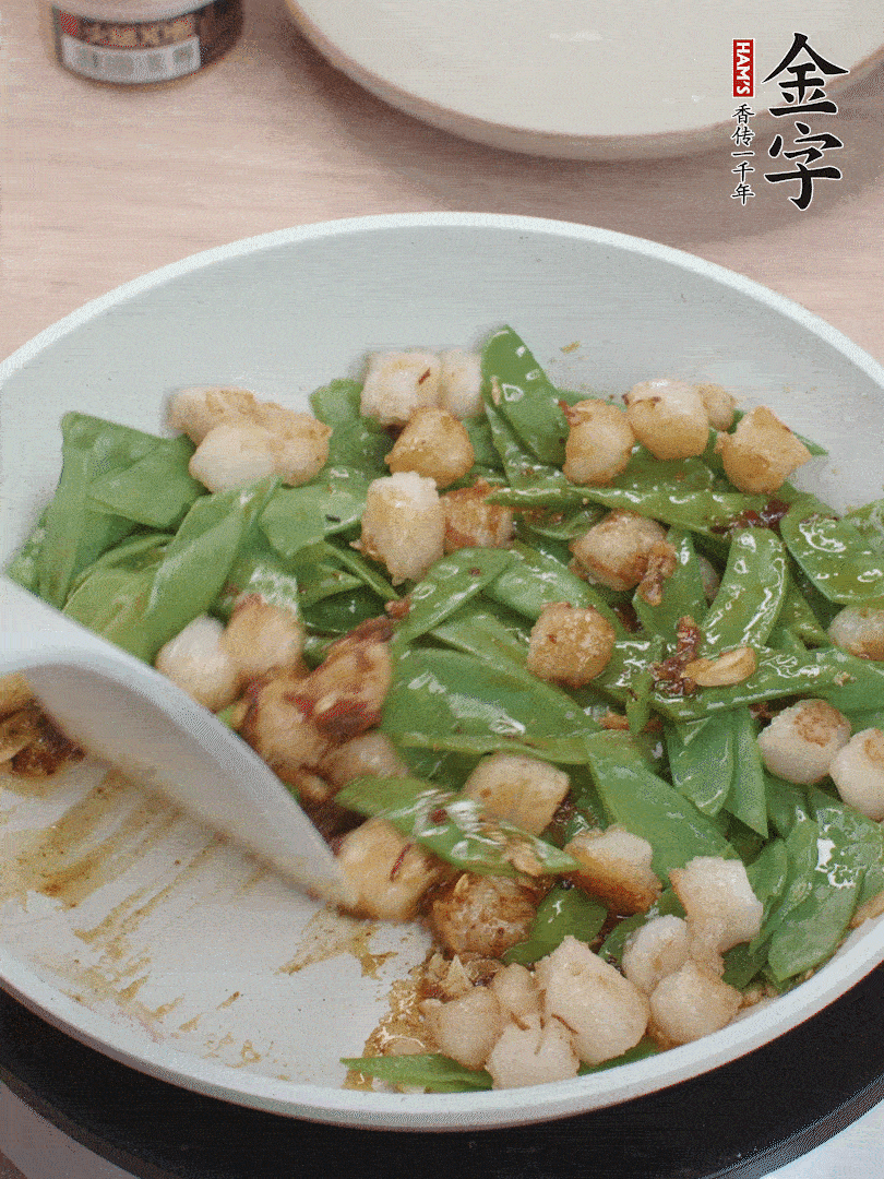 下甜豆莢、鮮貝輕輕翻炒均勻。