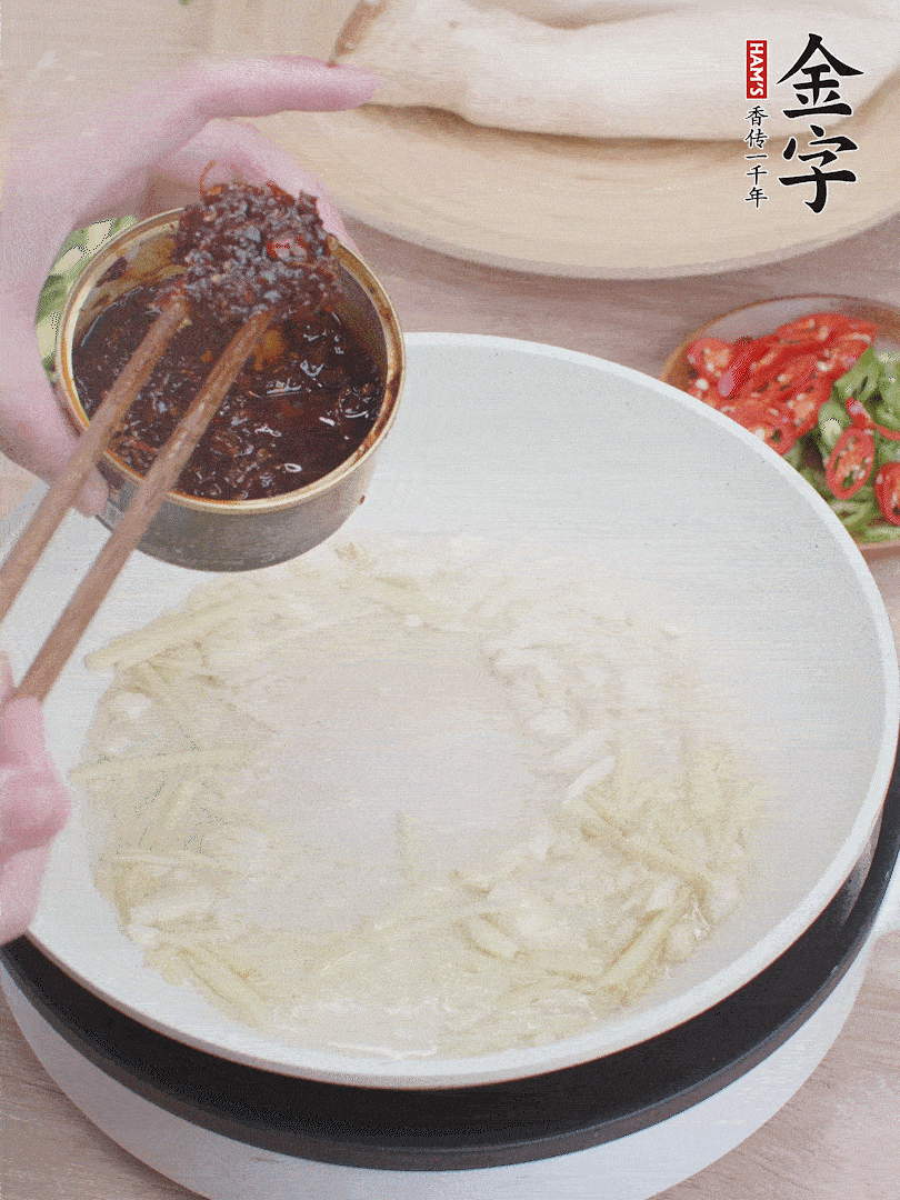 起鍋熱油，姜蒜、金字火腿干貝醬煸香。