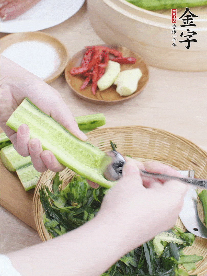 黃瓜削皮，對半切開，勺子挖去內(nèi)瓤，斜刀切片。青蒜斜刀切段。