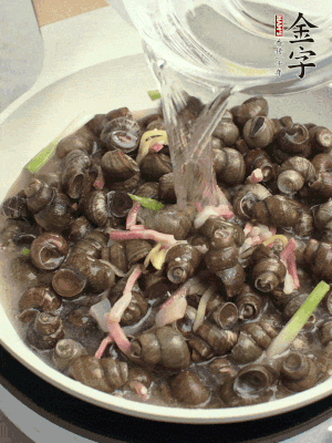 倒處理干凈的螺螄翻炒，加3勺料酒。加清水蓋過螺螄，中火蓋蓋煮5分鐘。