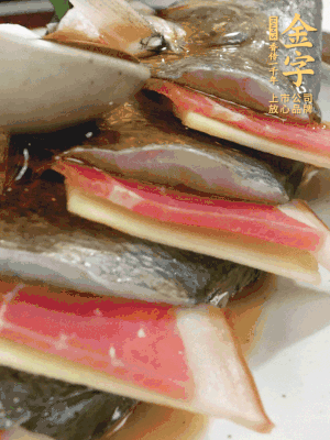 魚肚中塞蔥結(jié)、火腿片，魚身上碼放姜片、火腿片，倒入混合的料汁。