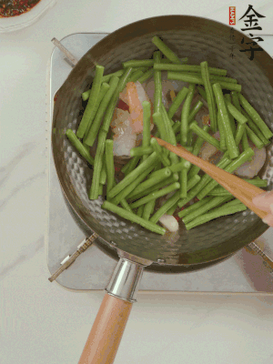 下掰好的缸豆段翻炒，略燜煮。