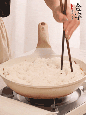 把瀝干水分的米飯均勻鋪在上面，筷子戳幾個洞，以便透氣，轉(zhuǎn)小火蓋上蓋子燜至水分收干，大概10分鐘。